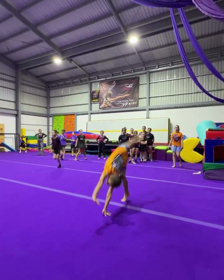 Atleta de AlilÚ Studio ejecutando un pase acrobático sobre la pista violeta